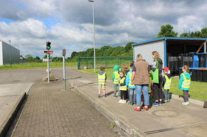 Gruppe Kinder mit Warnwesten auf Recyclinghof